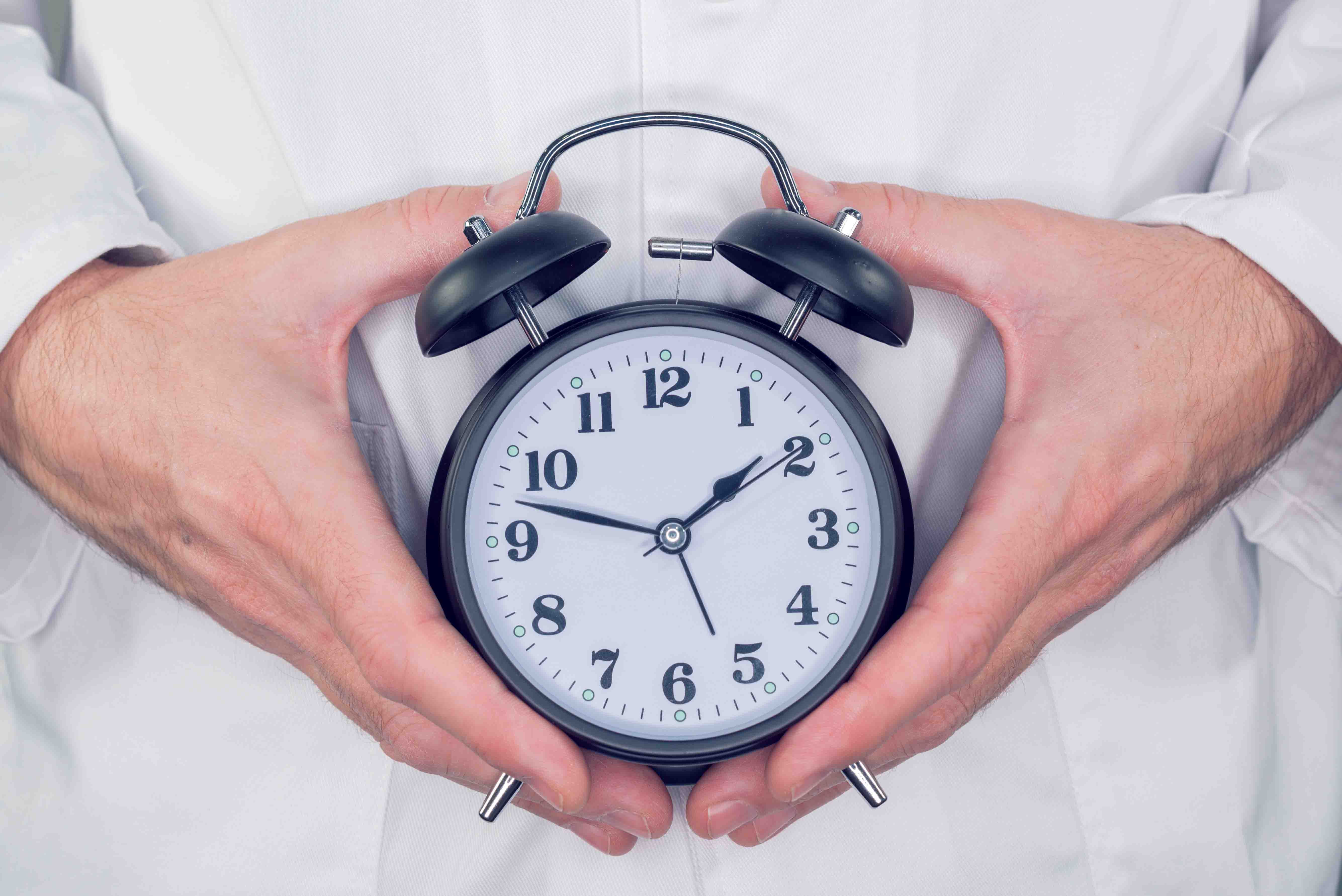 Doctor holding an alarm clock